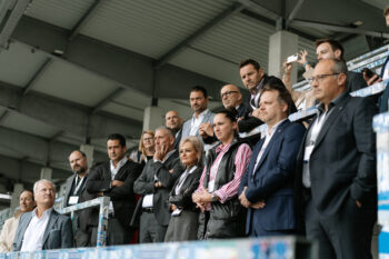 Menschen in Business Kleidung stehen auf der Stadiontribühne